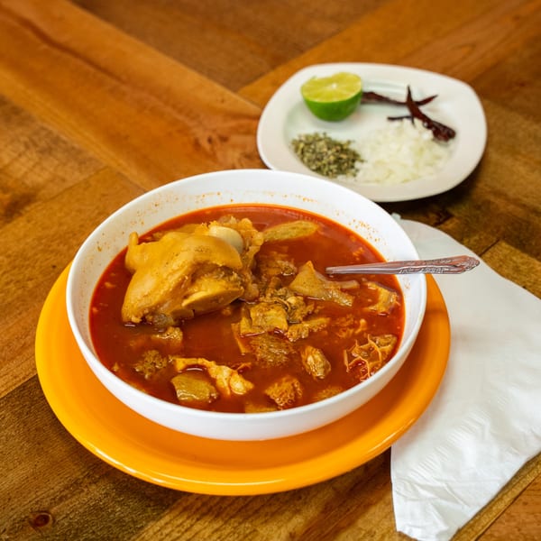 Menudo soup with tripe and a pig's foot, served with lime, onions, and dried chiles.